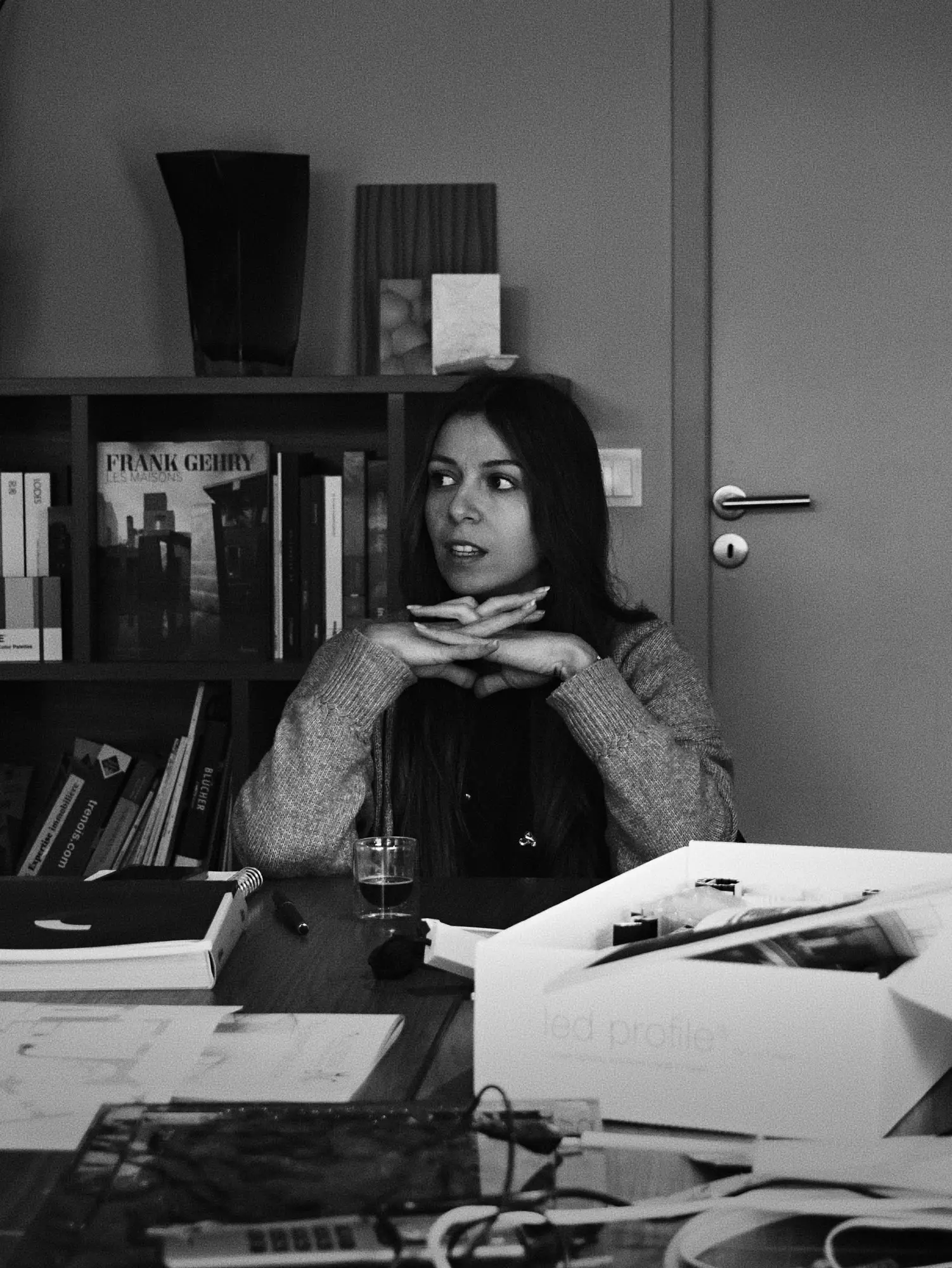 Marion Cogno à sa table de travail, en noir et blanc